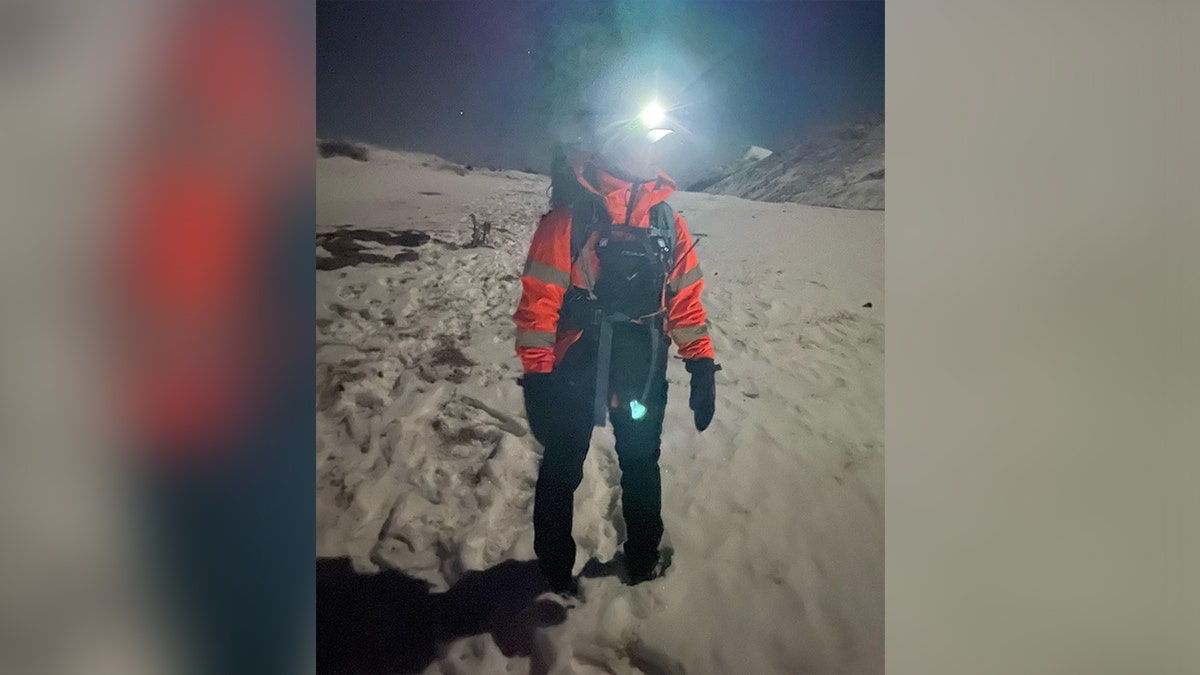 A rescue worker walking along a mountain in Colorado