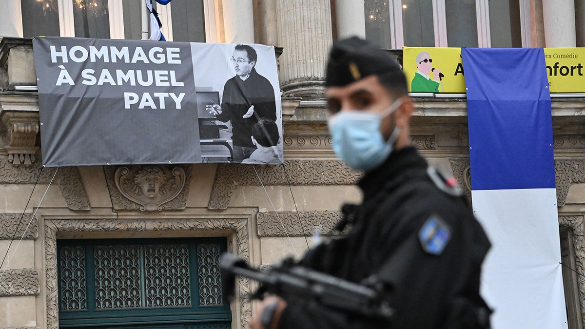 Samuel Paty poster on display with French police officer